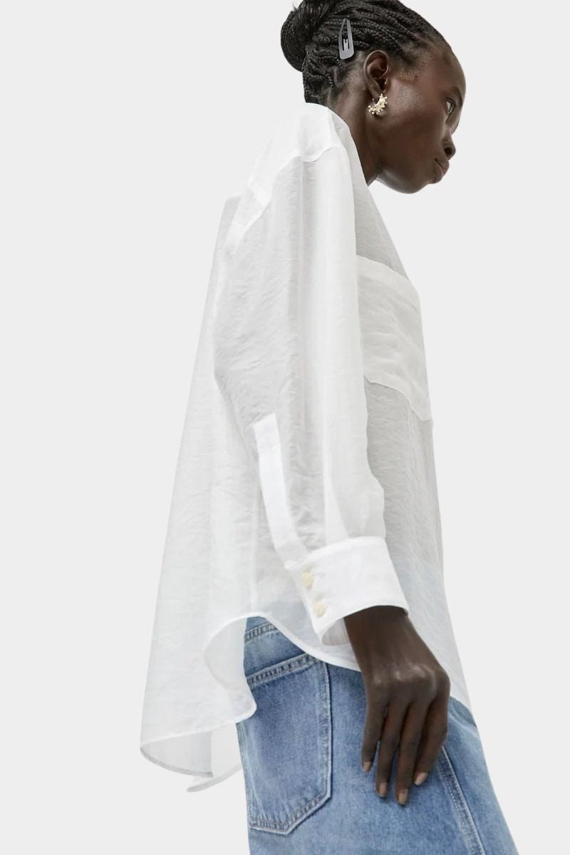 No.6 Lake Shirt in White Organza shown from the side with semi sheer oversized silhouette, curved hem, elongated cuffs, and lightweight airy drape.