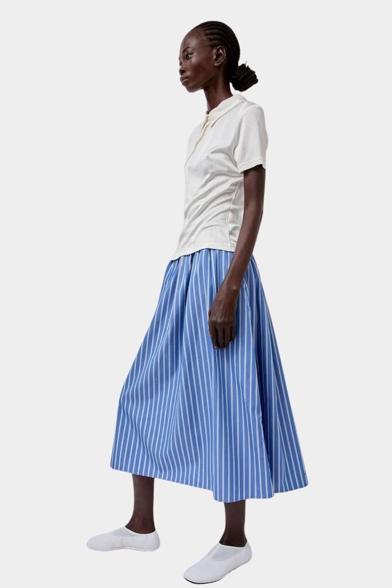 No.6 Mel Skirt in Eton Stripe blue and white cotton A-line midi skirt styled with cream short sleeve polo and white slip on shoes