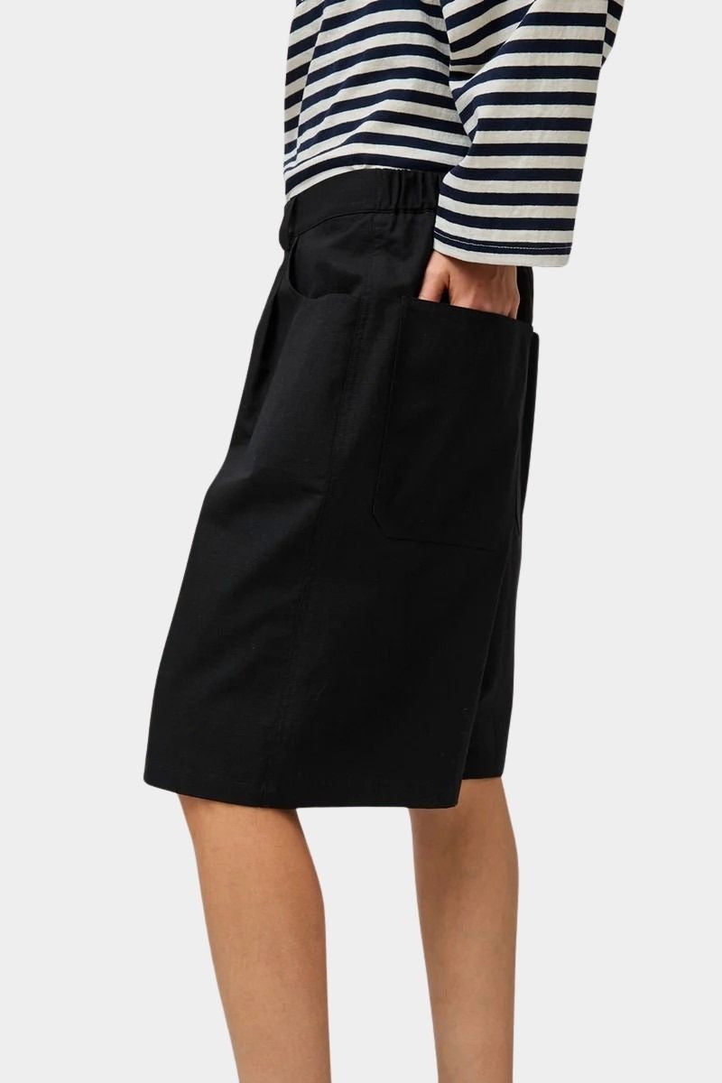 No.6 Mick Short in black cotton ripstop high-rise bermuda shorts side view with hand in pocket styled with striped long sleeve top