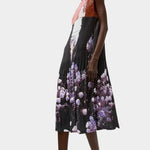 Side profile of the No.6 Tierney Dress in Eclipse with pleated texture, relaxed sleeveless fit, midi length, and dark floral photo print.