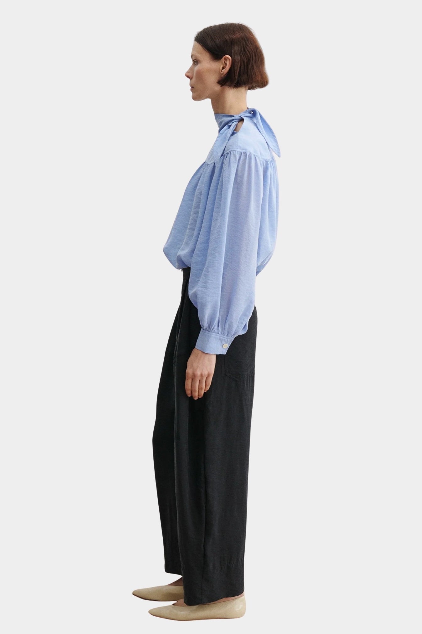 Rachel Comey Dini pant in black, side profile showing clean tailored line and subtle volume through the leg