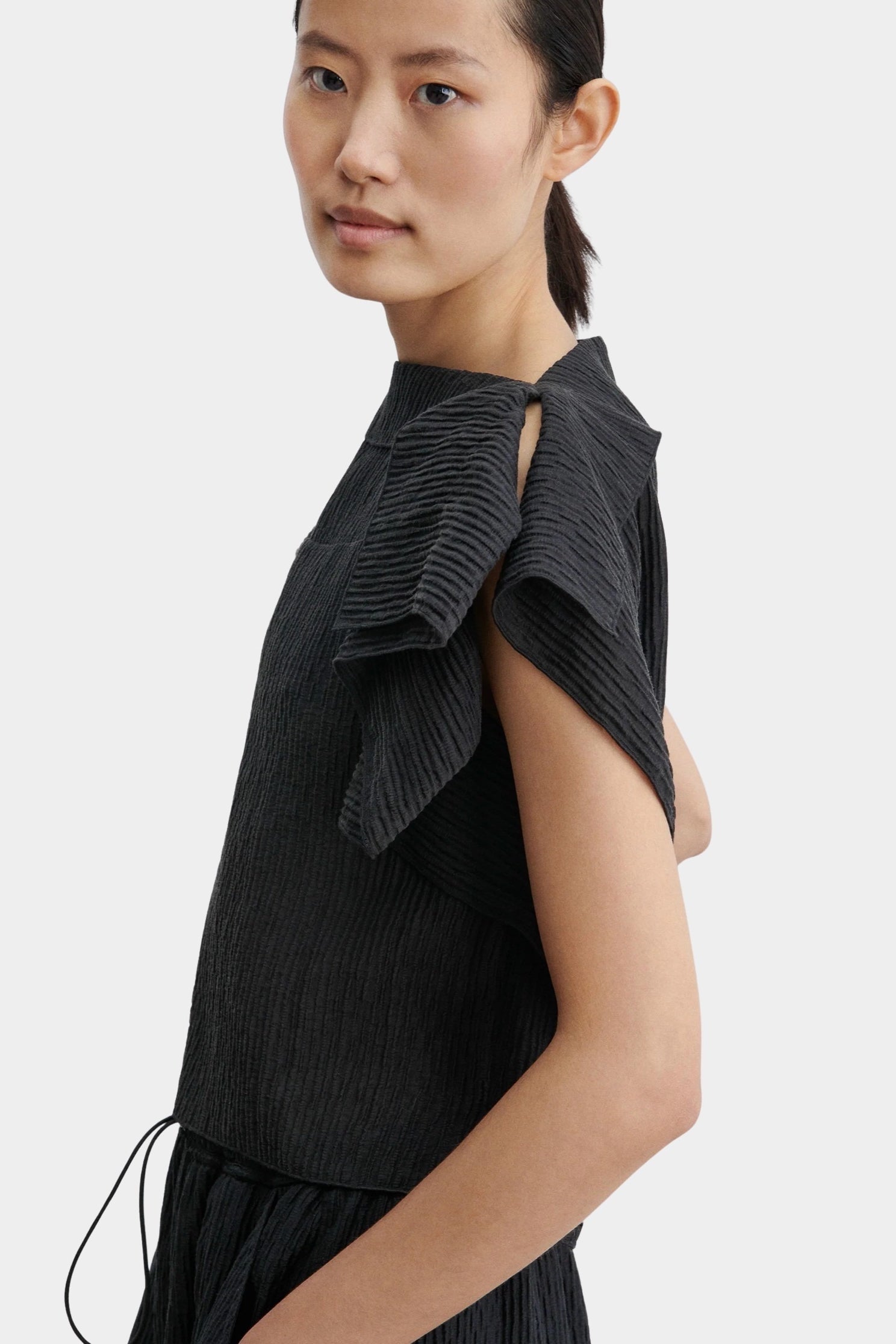 Rachel Comey Rivera Top Black, close-up side view showing pleated texture and layered ruffle sleeve detail