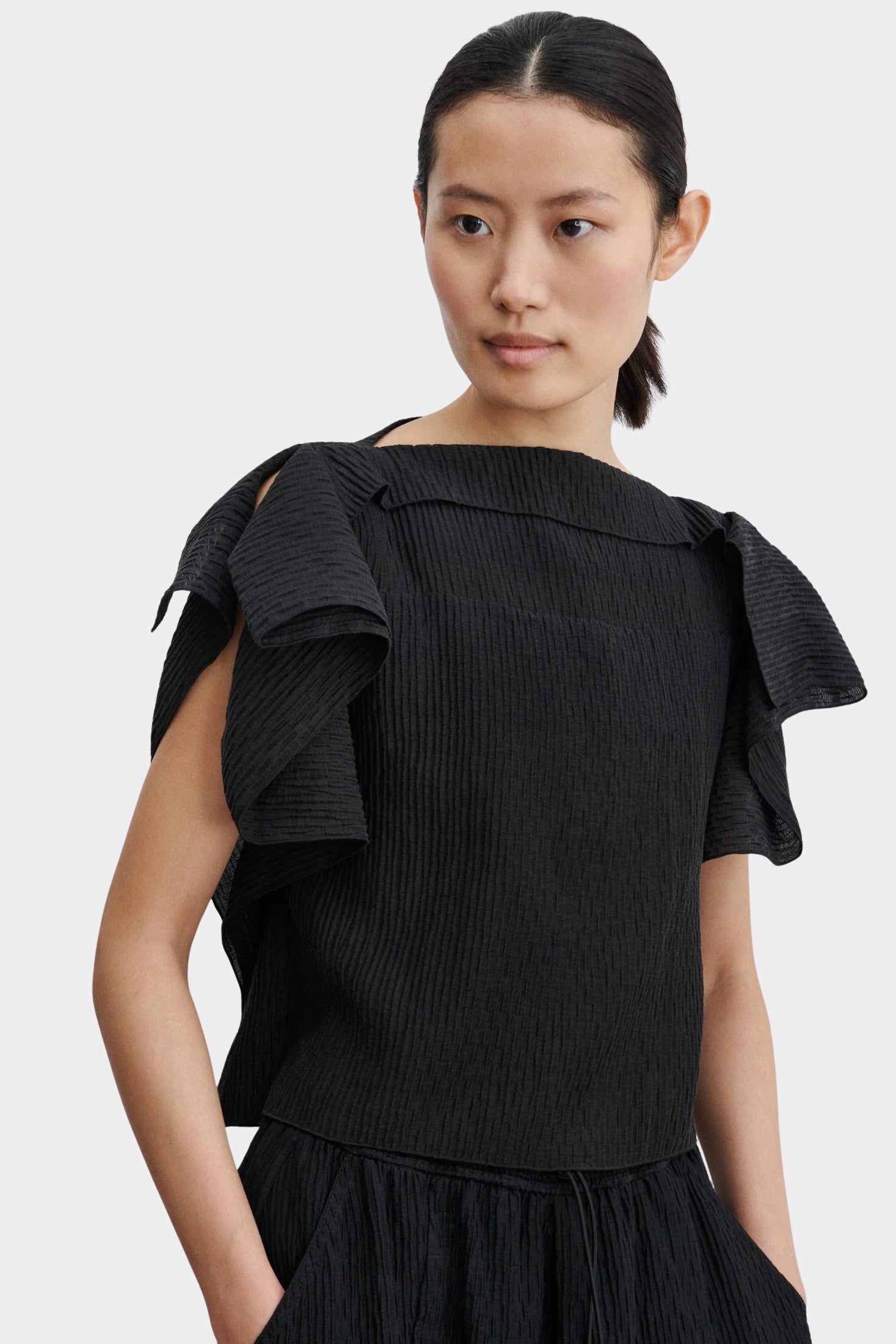 Rachel Comey Rivera Top Black, textured pleated black top with wide ruffle cap sleeves and boat neckline, front view