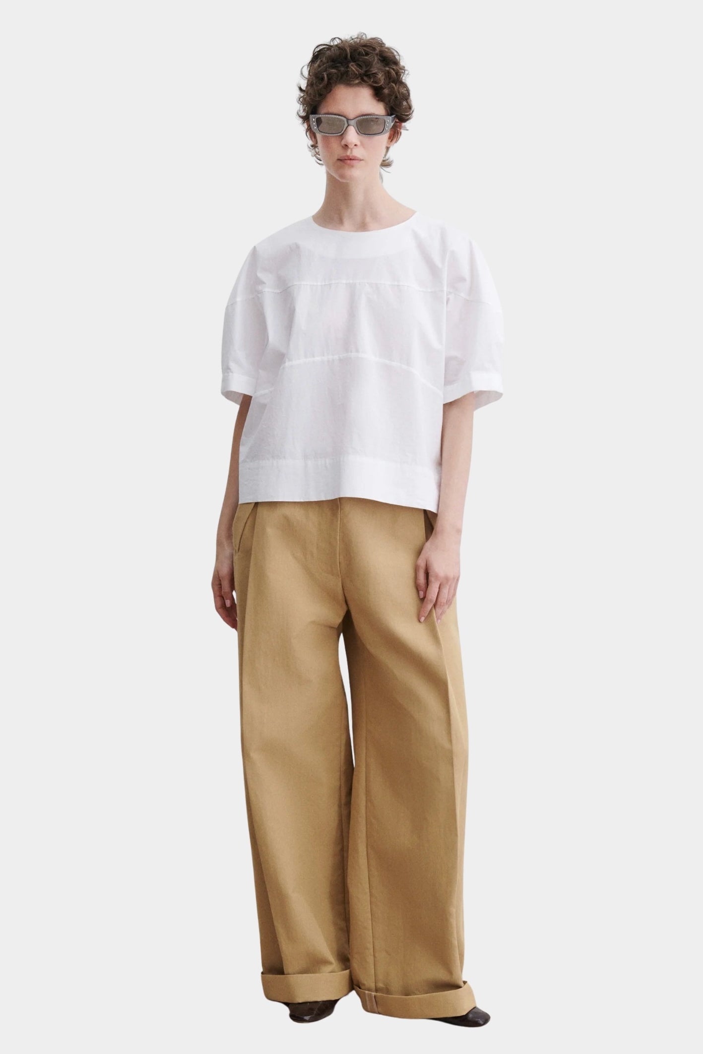 Rachel Comey rugby top in white cotton with relaxed boxy fit, wide short sleeves, and subtle panel seam detailing, styled with tan trousers