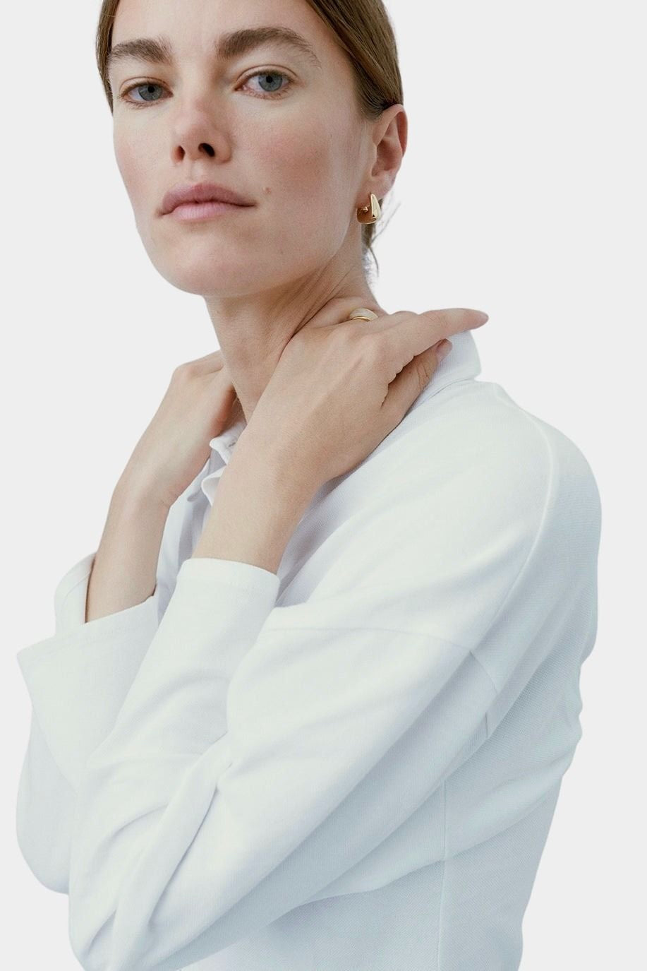 Model wearing RAGBAG Studio Datura Hoops in Gold with a white blouse, highlighting the polished finish
 Copy