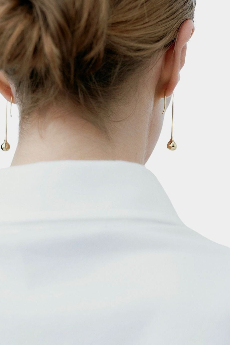 RAGBAG Studio Datura Long Drop Earrings in Gold worn from behind, showing the elongated sculptural silhouette