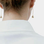 RAGBAG Studio Datura Long Drop Earrings in Gold worn from behind, showing the elongated sculptural silhouette