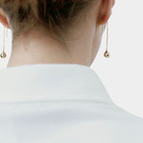 RAGBAG Studio Datura Long Drop Earrings in Gold worn from behind, showing the elongated sculptural silhouette