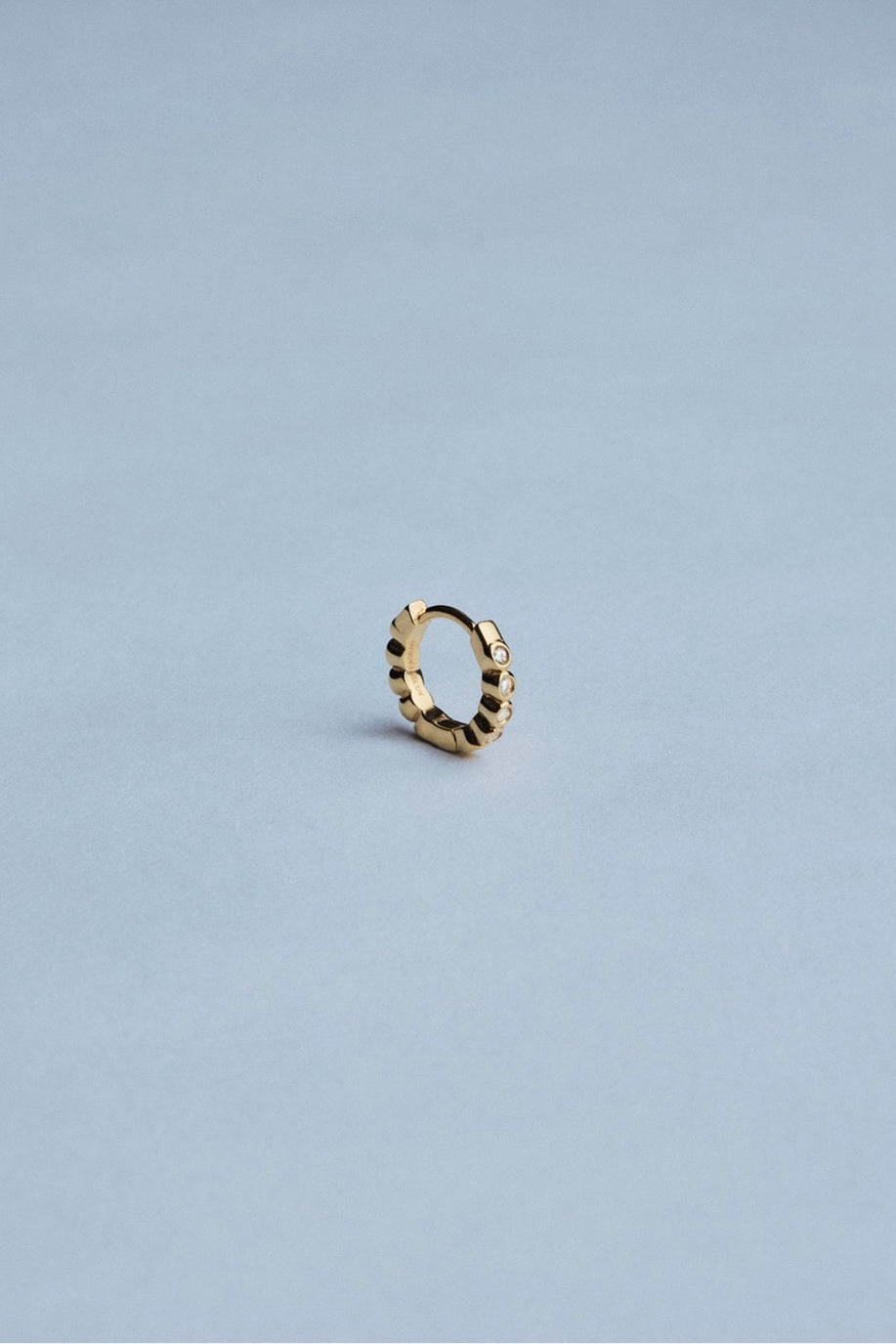 Front view of RAGBAG Studio Oda Mini Hoops with sparkling cubic zirconia stones in gold settings