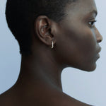 Side profile of model wearing delicate Odette gold earrings with graduated crystal settings