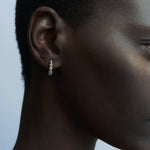 Close-up of RAGBAG Studio Odette Earrings in Gold with sparkling bezel set stones at YUCCA Denver
