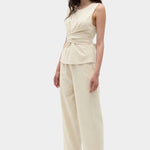 Rita Row Holan top in beige sleeveless wrap top styled with wide leg pants full outfit view