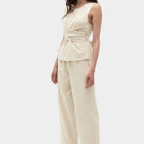 Rita Row Holan top in beige sleeveless wrap top styled with wide leg pants full outfit view