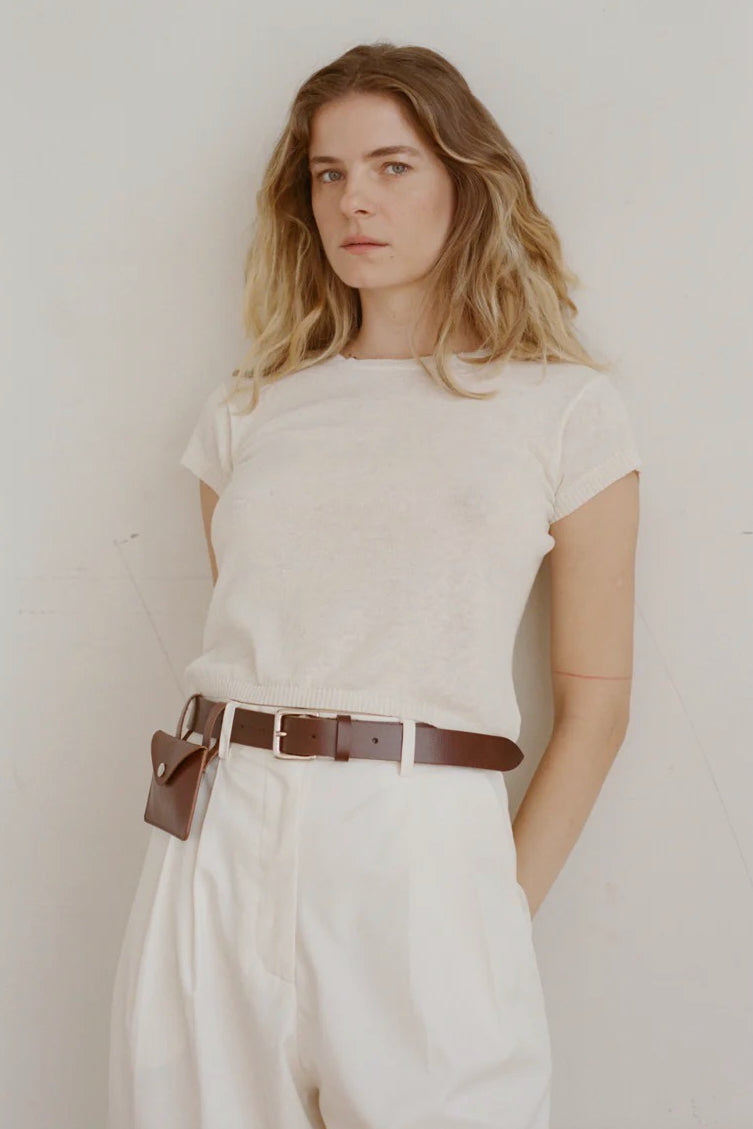 Shaina Mote Baby Tee Chalk soft knit tee styled with high-waisted ivory pants and cognac belt with pouch