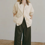 Shaina Mote Painter Coat Butter relaxed canvas jacket styled open with black wide leg pants and minimal leather sandals