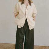 Shaina Mote Painter Coat Butter relaxed canvas jacket styled open with black wide leg pants and minimal leather sandals