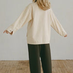 Shaina Mote Painter Coat Butter back view relaxed fit canvas coat styled with black wide leg trousers and leather sandals