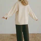 Shaina Mote Painter Coat Butter back view relaxed fit canvas coat styled with black wide leg trousers and leather sandals