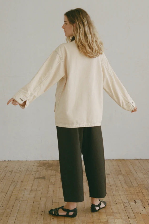 Shaina Mote Painter Coat Butter back view relaxed fit canvas coat styled with black wide leg trousers and leather sandals