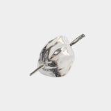 Close view sculptural silver hair pin high polish metal surface