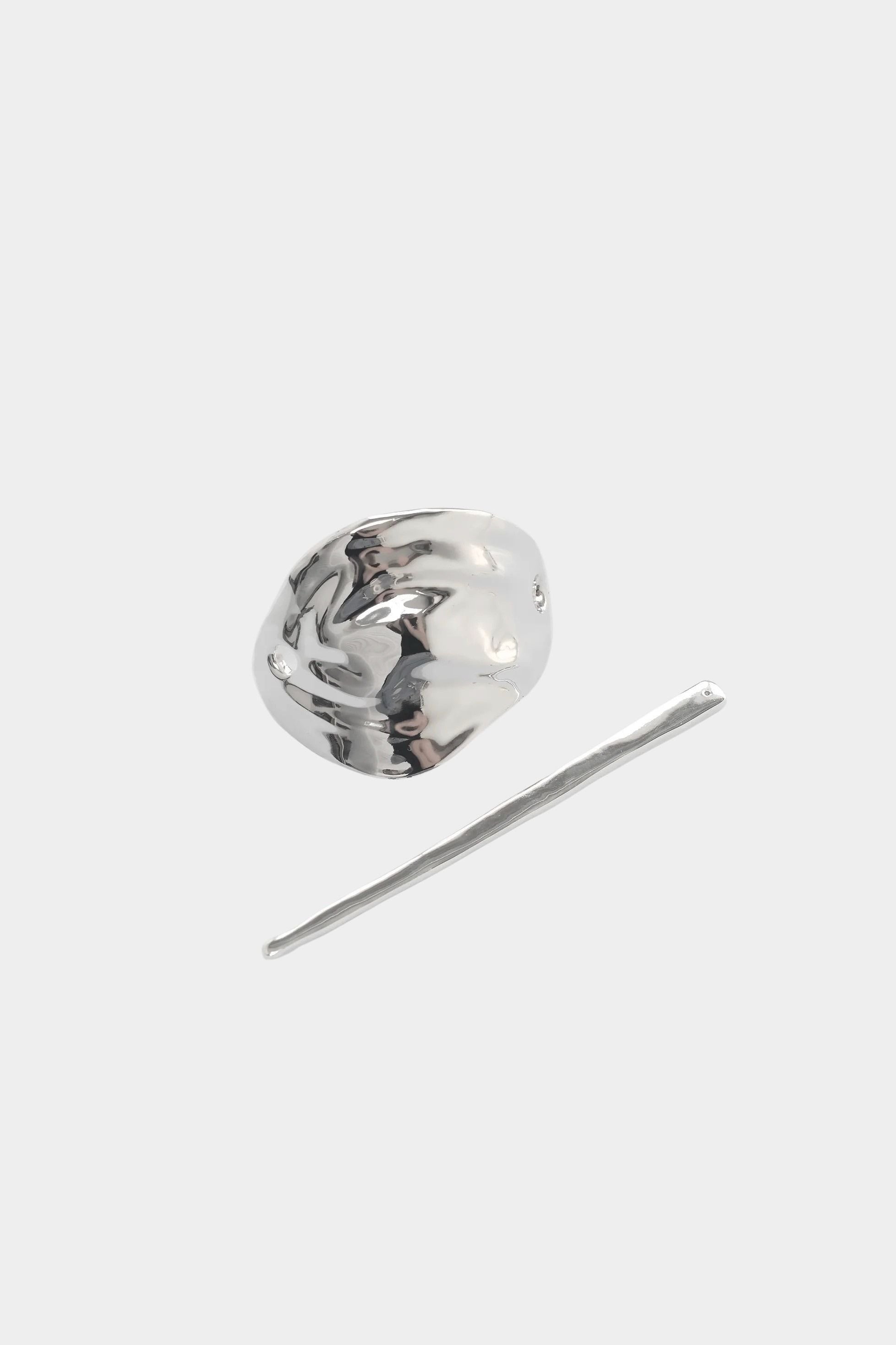 Silver bean shaped hair pin with stick detail flat lay