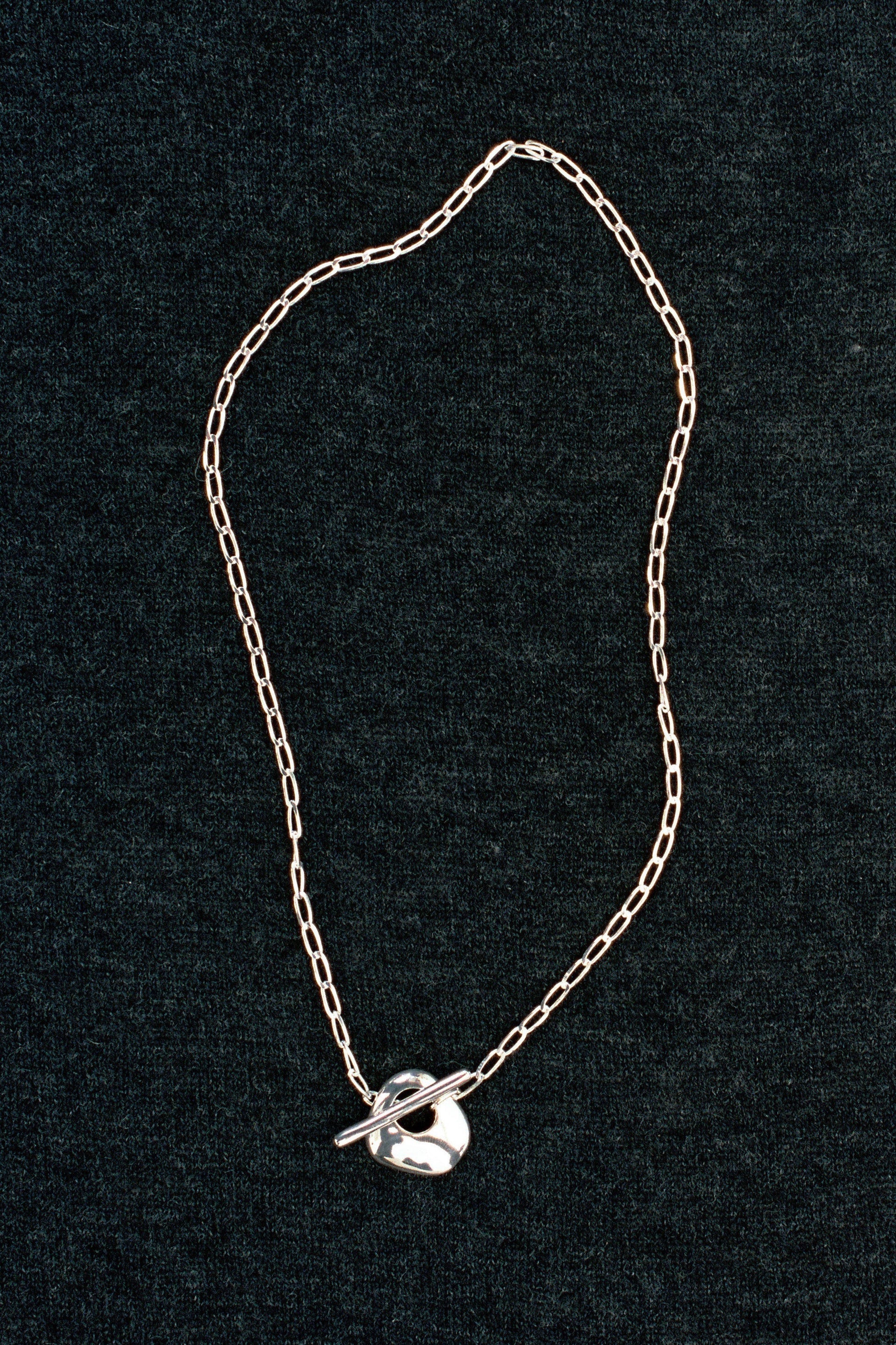Wolf Circus Kaia necklace sterling silver curb chain on dark textured background