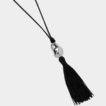 Miriam Necklace in silver Wolf Circus black cord tassel necklace flat lay sculptural pendant
