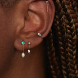 Large opal and pearl shower earrings worn in a layered WWAKE ear stack