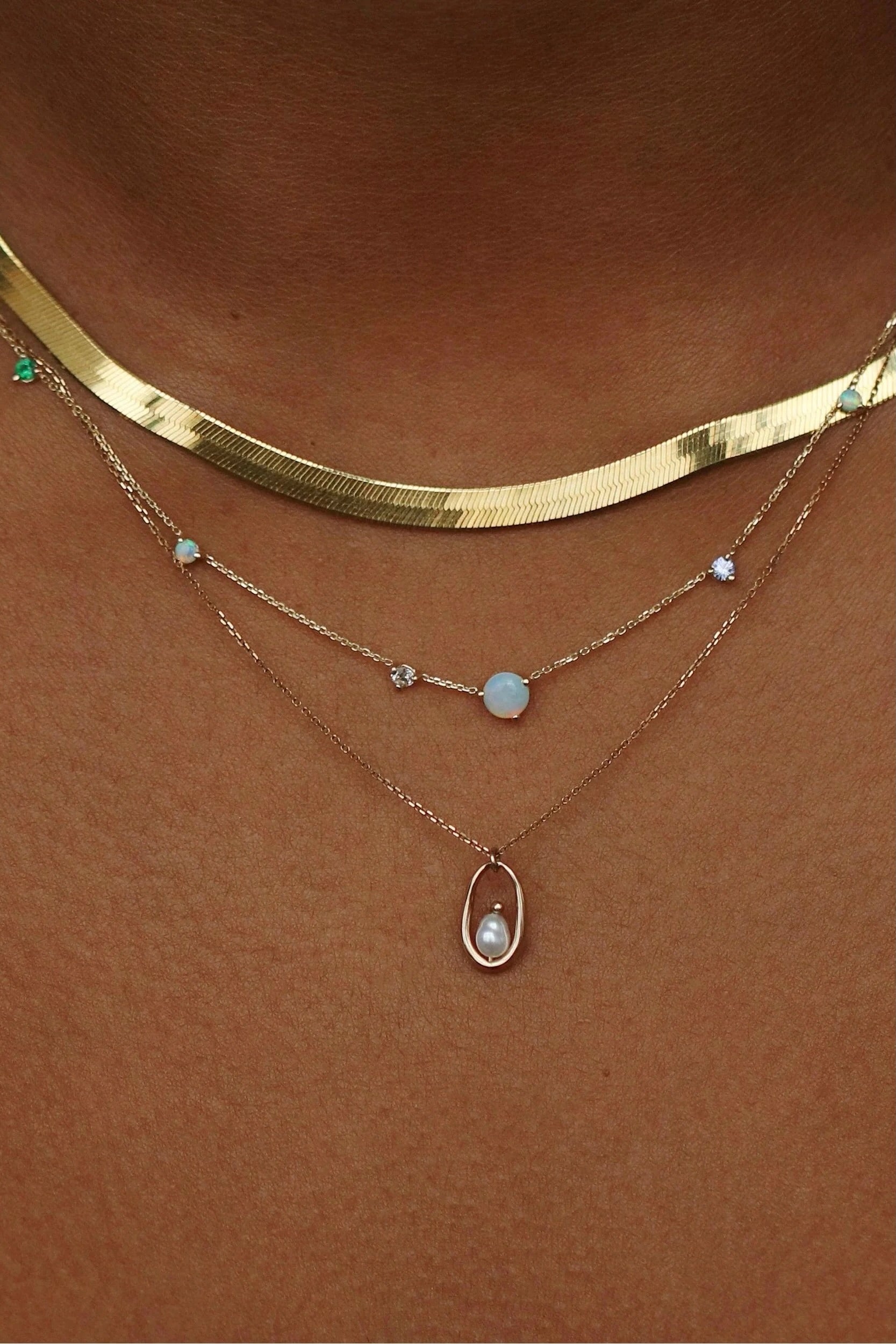 Opal and diamond linear chain necklace layered with delicate gemstone jewelry