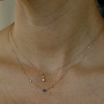 WWAKE Sapphire Three-Step Necklace worn with a solitaire diamond pendant, highlighting its delicate asymmetrical design