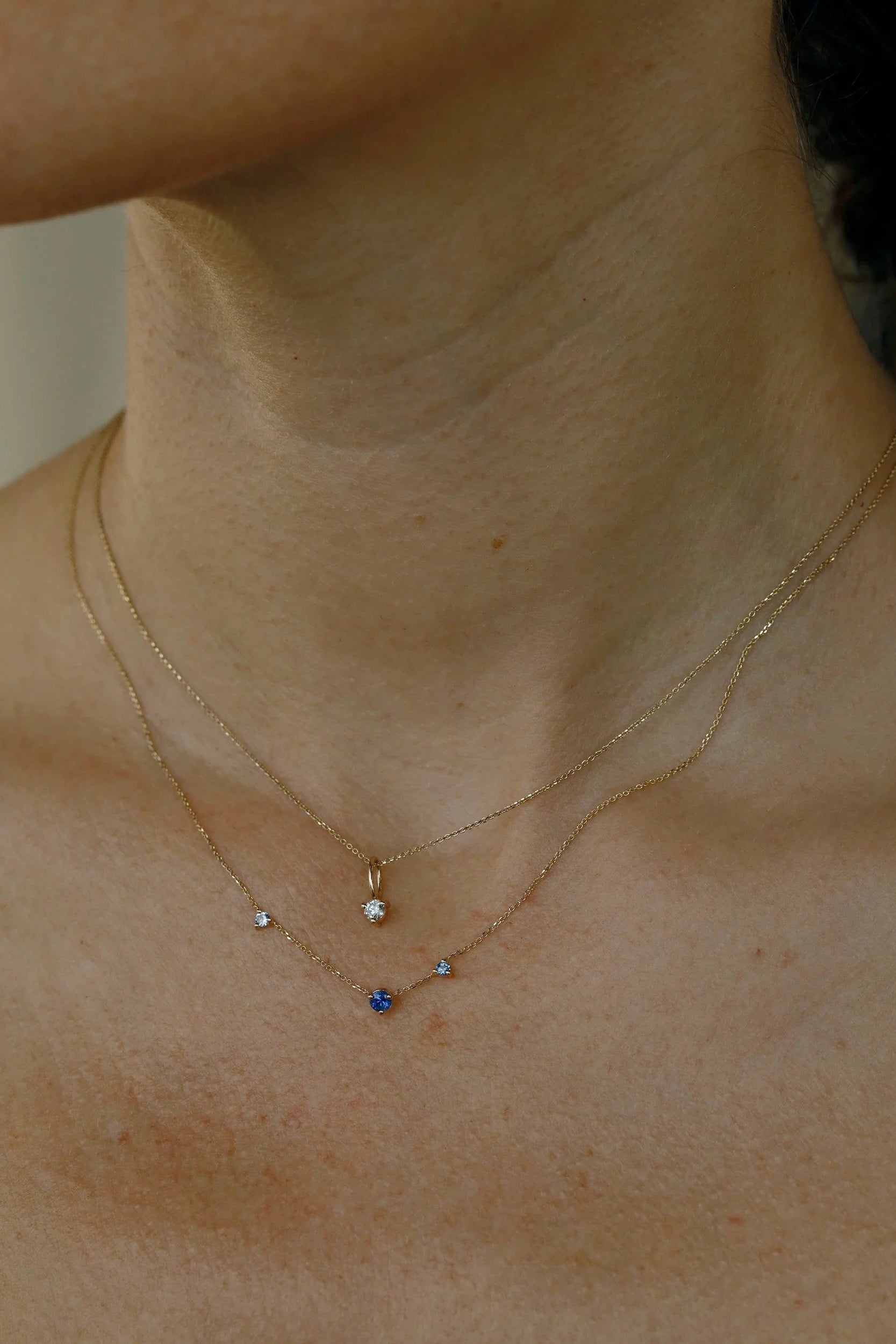 WWAKE Sapphire Three-Step Necklace worn with a solitaire diamond pendant, highlighting its delicate asymmetrical design